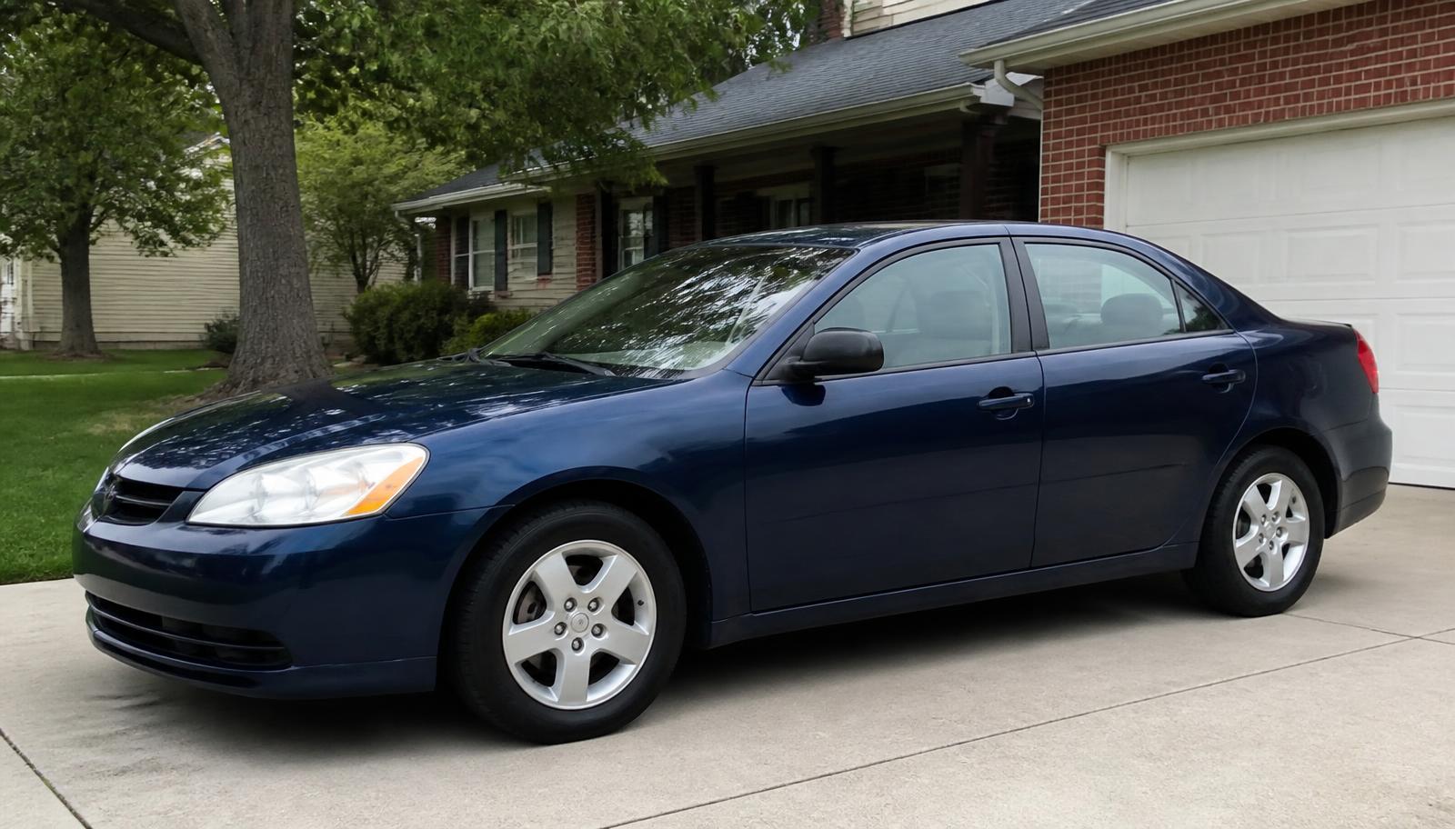 Clean dark blue used sedan parked in a driveway during a private sale